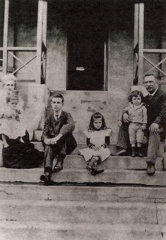 Pessoa na escadaria de sua casa em Durban com sua mãe, seu padrasto e três de seus cinco irmãos